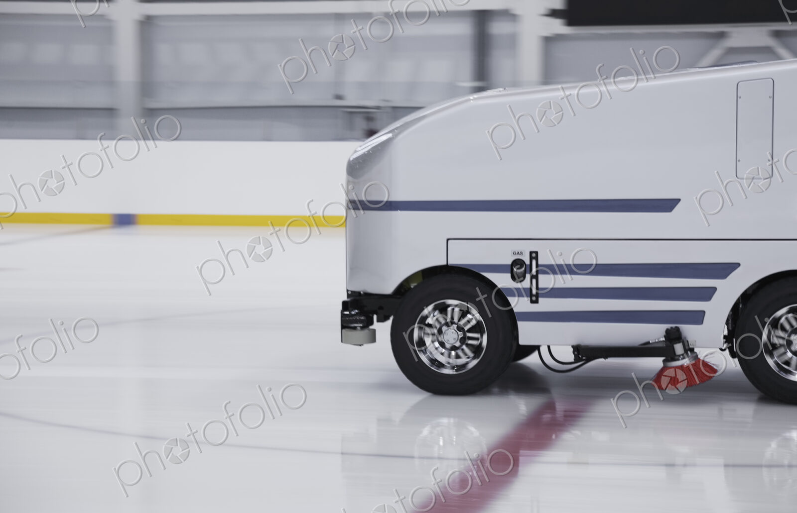 Zamboni ice resurfacing machinery, smoothing and repairing ice rink.