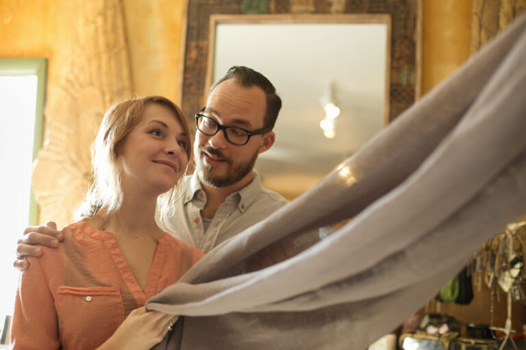 Two people, a couple running an antique store. Small business. Holding a piece of…