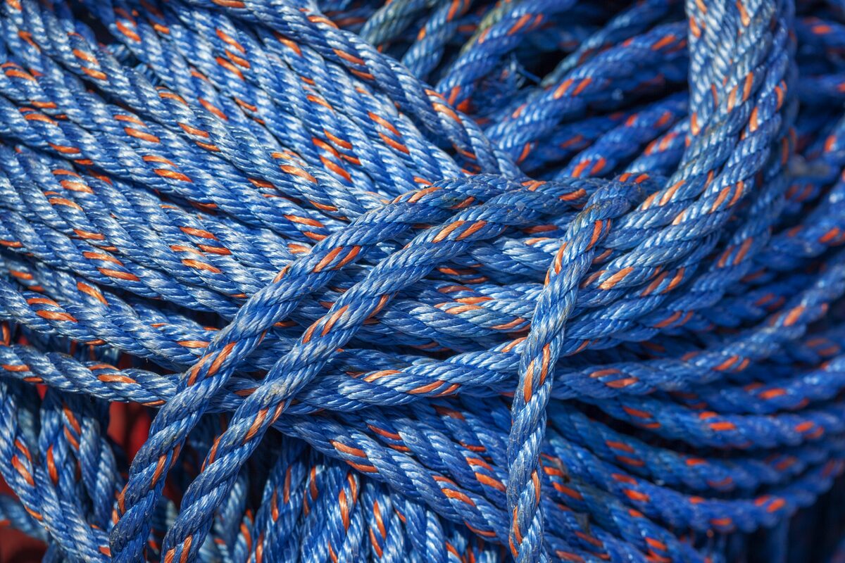 Abstract category — Close-up of coiled blue nylon rope with orange strands, tightly bundled and vibrant in… Close-up of coiled blue nylon rope with orange strands, tightly bundled and vibrant in…
