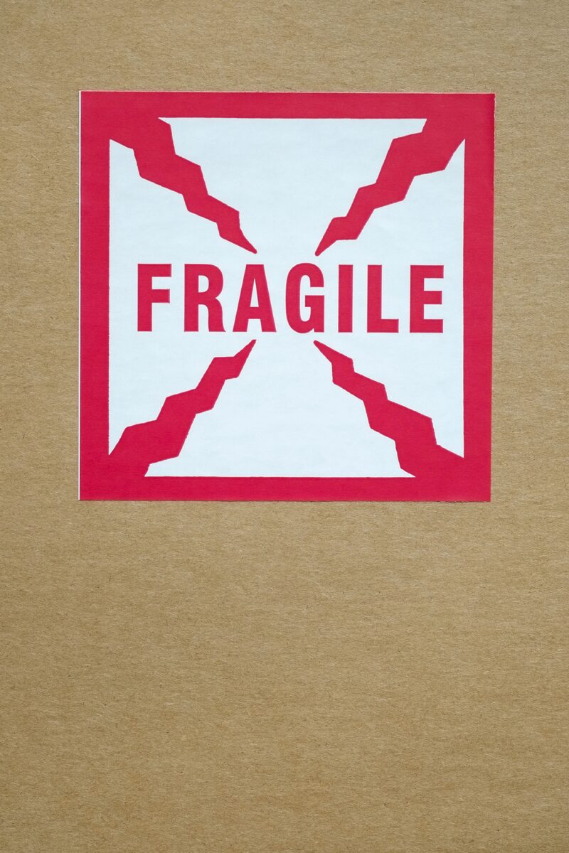 Animation-illustration category — Close-up of a red and white “Fragile” sticker with crack-like graphic elements on a… Close-up of a red and white “Fragile” sticker with crack-like graphic elements on a…
