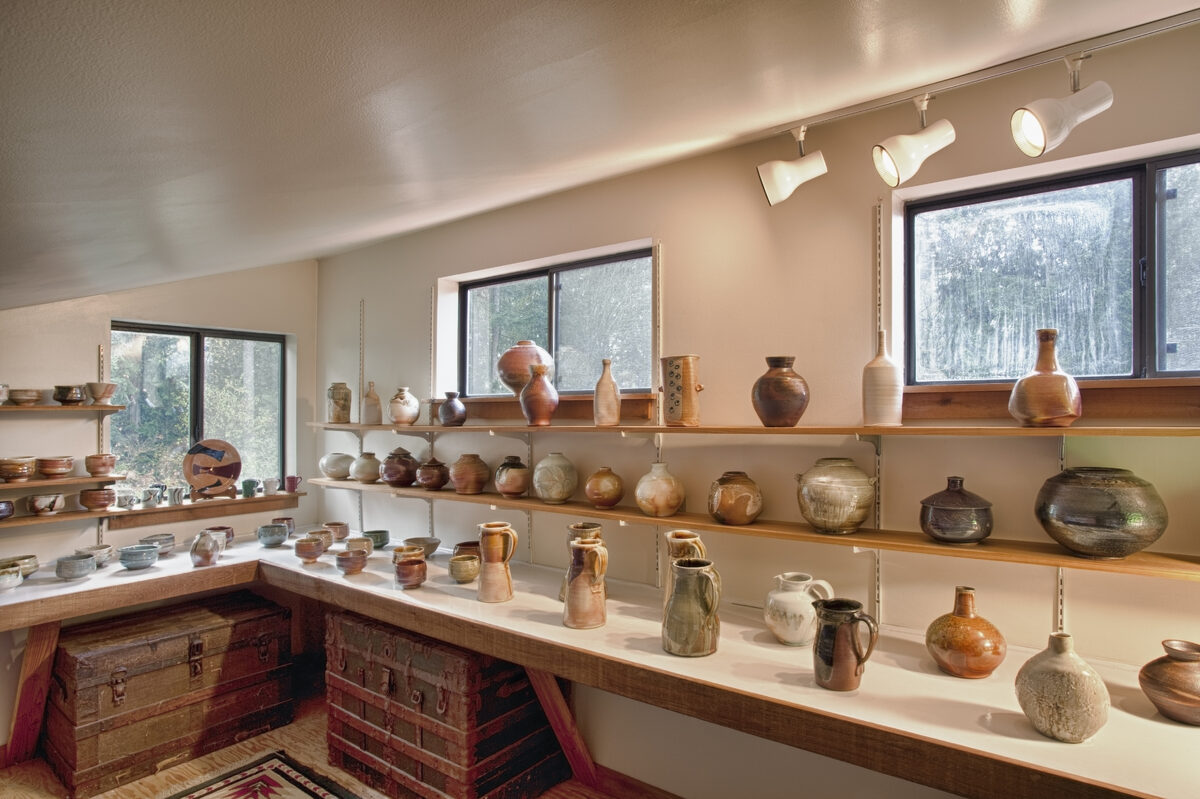 Interior view of a potter’s workshop, rows of completed ceramic work, vases and pots…