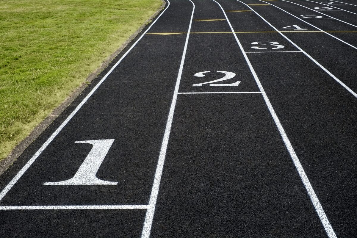 Sports category — View of a black asphalt running track with white lane markings and numbers – a symbol… View of a black asphalt running track with white lane markings and numbers – a symbol…